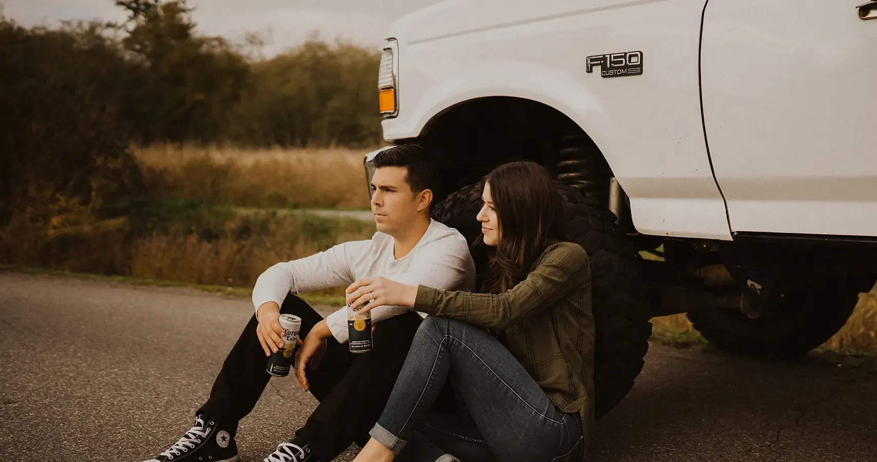  Couple drinking beer sitting against tire of truck | Jennifer Ginn Photography