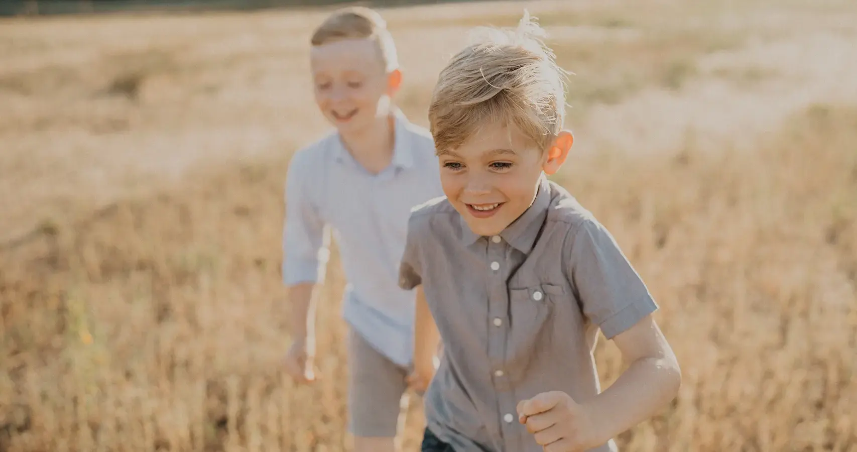 brothers smiling and running in a field | Jennifer Ginn Photography
